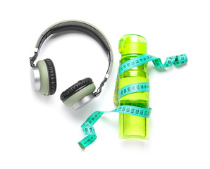 Bottle of water, measuring tape and headphones on white background. Weight loss concept
