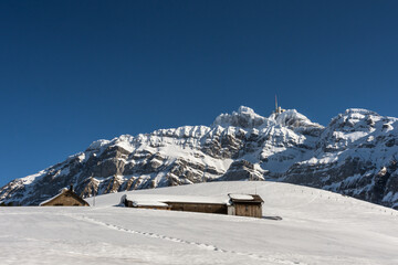 Fototapeta na wymiar Kleine Berghütten auf einer Alp vor dem Säntismassiv im Winter, Kanton Appenzell-Ausserrhoden, Schweiz