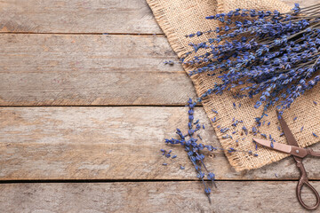 Beautiful lavender flowers and scissors on wooden background