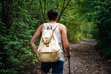 Portrait of a man hiker walking on the trail in the woods.