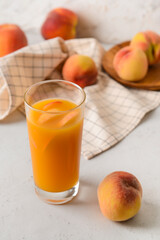 Glass of fresh peach juice on table