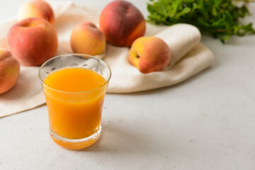 Glass of fresh peach juice on table
