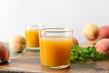 Glass of fresh peach juice on table