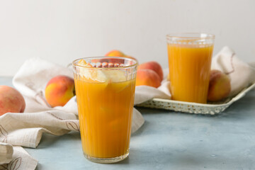 Glass of fresh peach juice on table