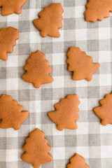 Top view of cookies in the shape of a Christmas tree on a checkered tablecloth
