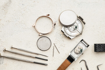 Watches and tools for repair on light background