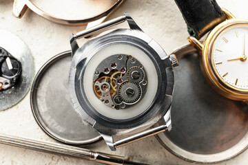 Watches and tools for repair on light background
