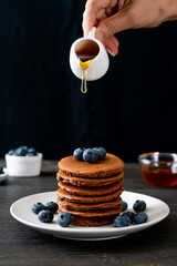 chocolate pancake stack with blueberry and honey