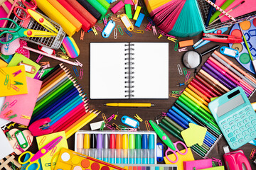 School supplies. Composition of colorful school accessories isolated on the brown table. Top view.