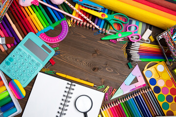 School supplies. Composition of colorful school accessories isolated on the brown table. Top view.
