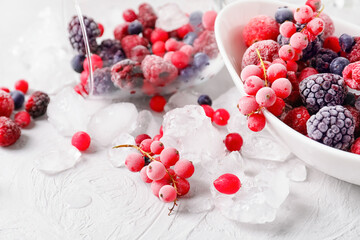 Bowl with tasty frozen berries and ice on table