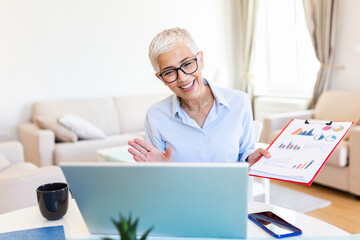 Mature businesswoman presenting charts and graphs on video call online. Middle-aged Business woman having conference call with client on laptop. Closeup business woman working laptop computer indoor.