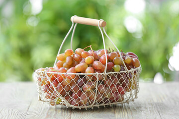 Basket with ripe grapes on table outdoors