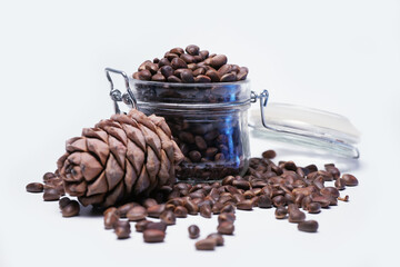 Pine nuts are in a glass jar on a white background