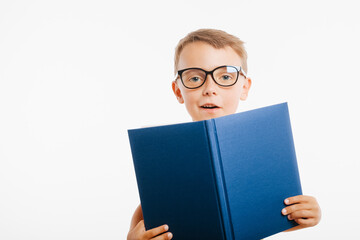 child reads a book against a bright wall