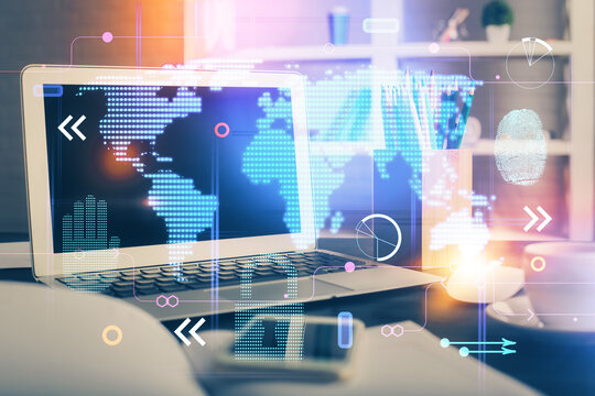 Double exposure of desktop with computer and world map hologram. International data network concept.