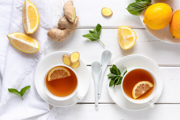 Antioxidant healthy tea with lemon, ginger and mint on a white wooden table. Alternative medicine concept.