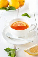 Vitamin, healthy tea with lemon and mint on a white wooden table. Alternative medicine concept.
