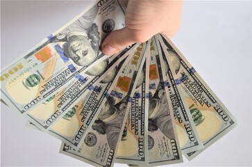 a lot of dollar bills, one hundred dollar bills held by a man's hand on a white background, earnings, business project