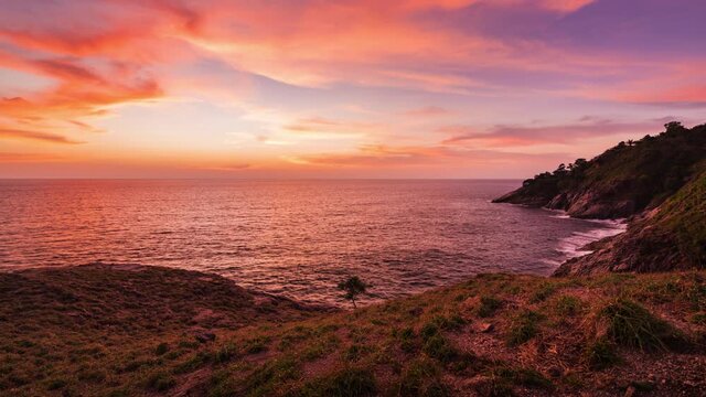 beautiful sunset on green grass coastline 4k time lapse, laem krating viewpoint at Phuket Thailand 