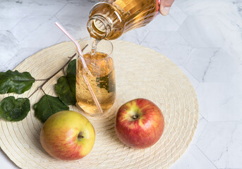 Pouring Apple juice into a glass Cup from a bottle. Horizontal orientation