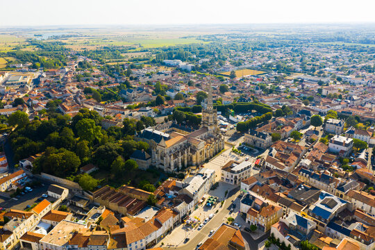 Picturesque summer view of Lucon looking out over Roman Catholic cathedral with tall Gothic bell tower, France..