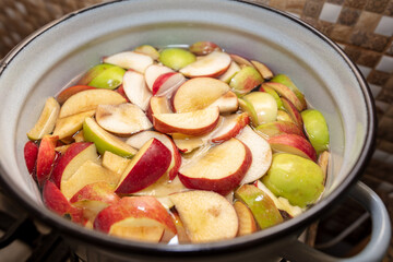 Chopped apples are boiled in a saucepan.
