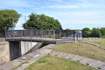 Fototapeta na wymiar Landscape View of Modern Pedestrian Bridge over Canal in Summer Sunshine 