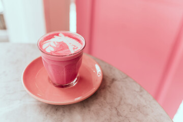 Two trendy beetroot lattes with latte art and flower petals on the foam.