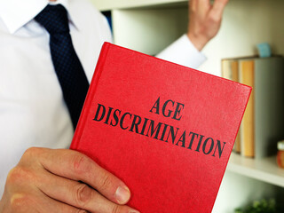 A lawyer shows an Age discrimination law book in the office.