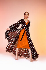 Glamour fashion woman long brunette hair natural evening makeup wear sexy silk long dress polka dot...
