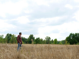 A man stands alone in an autumn field. Loneliness and travel.