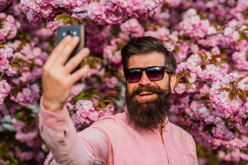 Personal blog. Selfie with sakura. Man taking selfie photo smartphone. Streaming online video call....