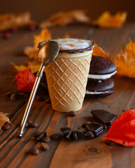 A warm autumn coffee in a waffle cup with tasty cookies