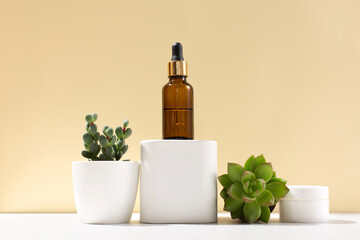 Cosmetic bottle with pipette on beige background, various cactus and succulent plants in white pot.