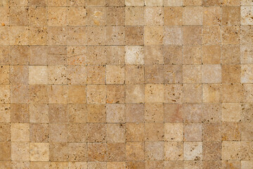 Wall background with Yellow natural sandstone tiles stitched together with clay