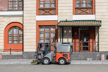 Fototapeta na wymiar Gorki Gorod, Sochi, Russia. July 9, 2020 : a small orange utility car sweeps the streets of the city