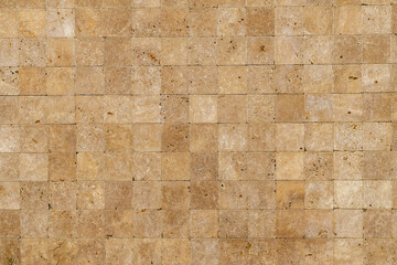 Wall background with Yellow natural sandstone tiles stitched together with clay