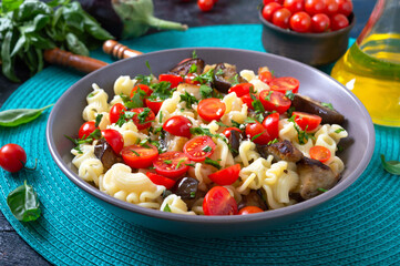 Pasta creste with grilled eggplant, cherry tomatoes and herbs. Delicious warm salad.