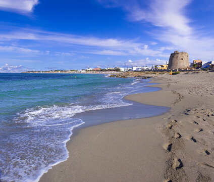 Torre Mozza beach in Salento, Apulia (Italy). The ruined watchtower overlooks the long beach of Torre Mozza, with fine sand, lapped by the crystal clear water.