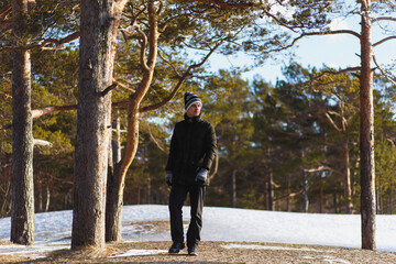 Young caucasian man in a warm winter clothes in the coniferous winter forest in north Russia.