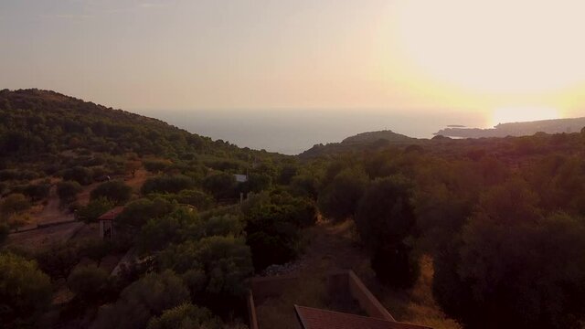 Flying over Marina di Camerota mountains in backlight at sunset