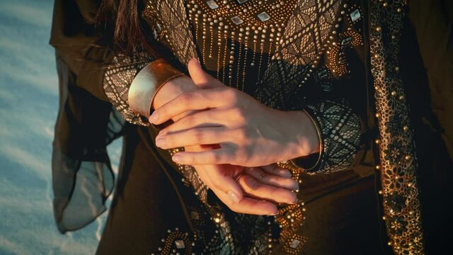 Hands of an oriental woman close up. Luxurious black clothes with gold embroidery. Egyptian Bedouin style.