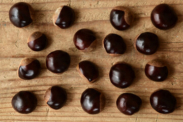 Chestnuts isolated on wooden background.