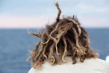 rasta man hair in the wind looking at the ocean