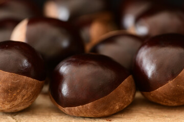 Chestnuts isolated on wooden background.