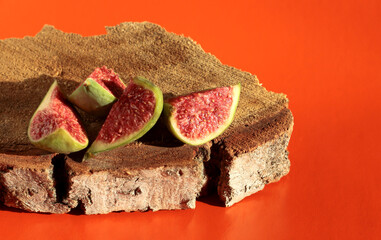 Fig slices on a wooden background. Figs on a bright orange background.