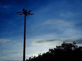 Blue sky background with cloud shade and a view from street of strret light and a tree