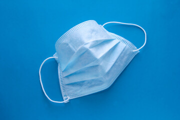 Expanded medical mask on a blue background. Respiratory protection.