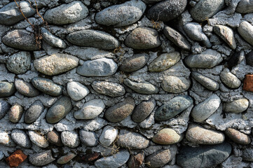 antico muro a spina di pesce con sassi di fiume